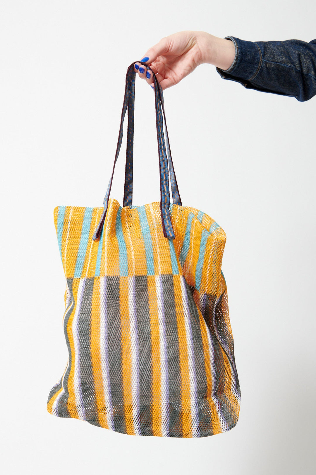 Model holding Épice Extra Large Stripe Mesh Tote front view