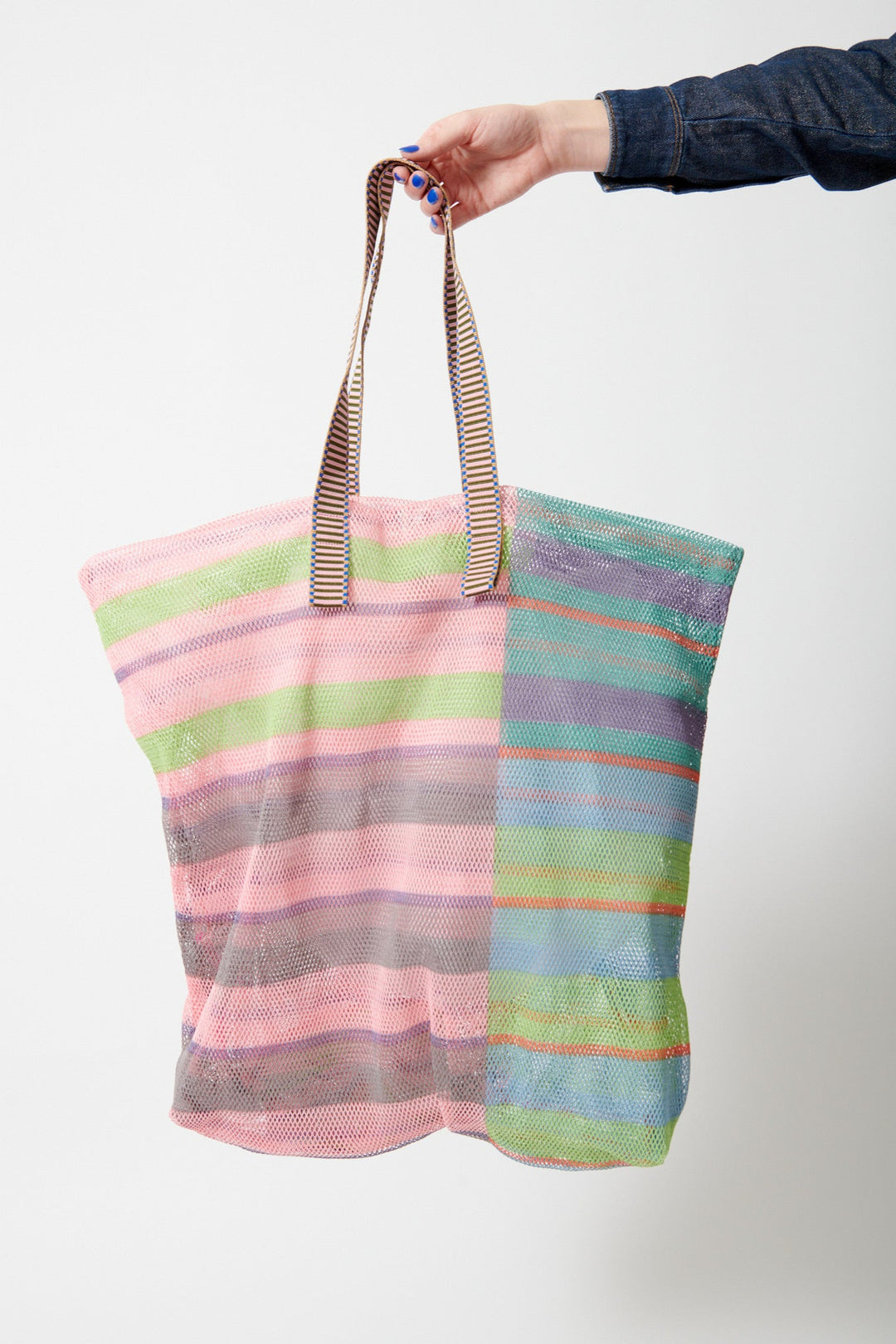 Model holding Épice Extra Large Stripe Mesh Tote front view
