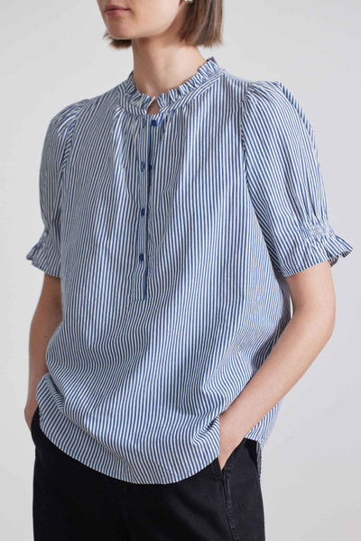 Close-up view of model wearing short-sleeved button down navy stripe shirt