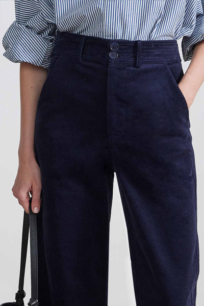 Close-up front view of model wearing midnight blue corduroy pants