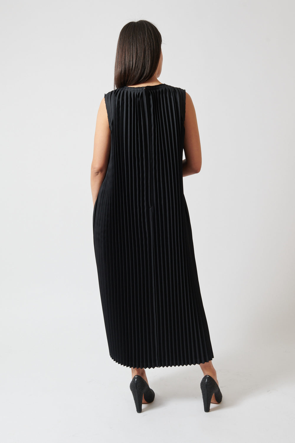 Amanda wearing Comme des Garçons Sleeveless Poly Accordion V Dress rear view