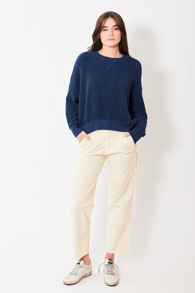 Front view of model wearing cream carpenter pants