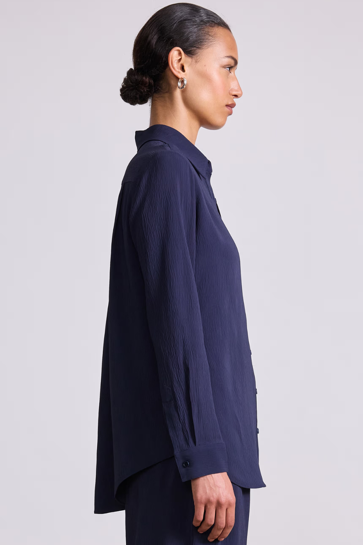 Model wearing Apiece Apart Sodi Wrap Button Up side view