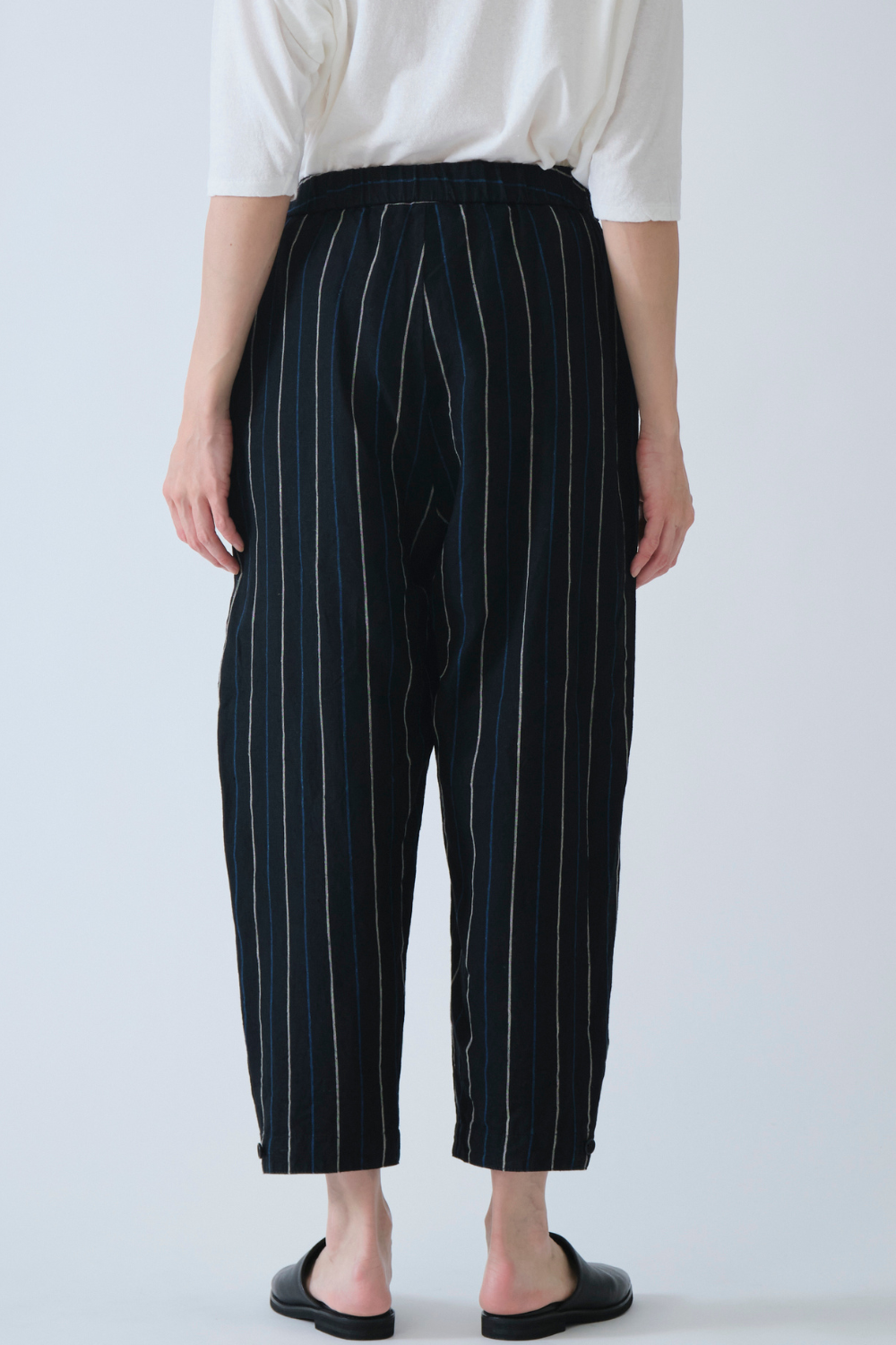 Model wearing Pas de Calais Linen Indigo Stripe Cropped Pants rear view