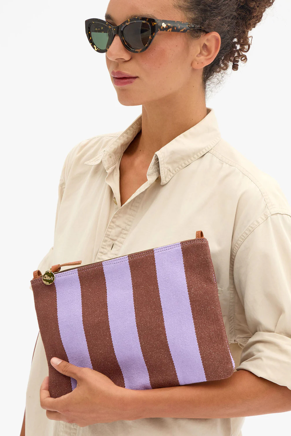 Model wearing Clare V. Flat Clutch w/ Tabs Jacaranda Hazelnut Canvas Stripe front view
