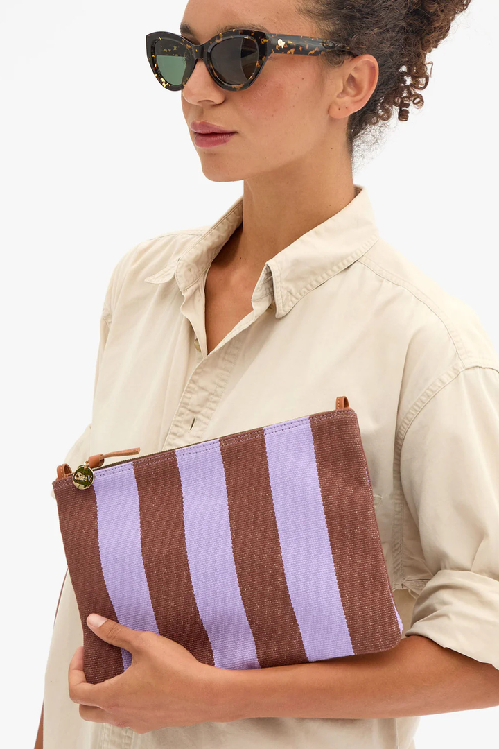 Model wearing Clare V. Flat Clutch w/ Tabs Jacaranda Hazelnut Canvas Stripe front view