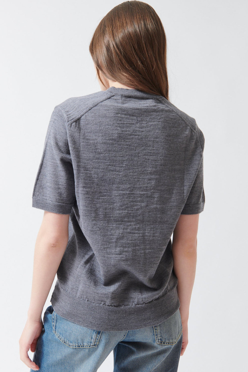 Angela wearing Comme des Garçons PLAY Red Heart Emblem Short Sleeve V Sweater Grey rear view