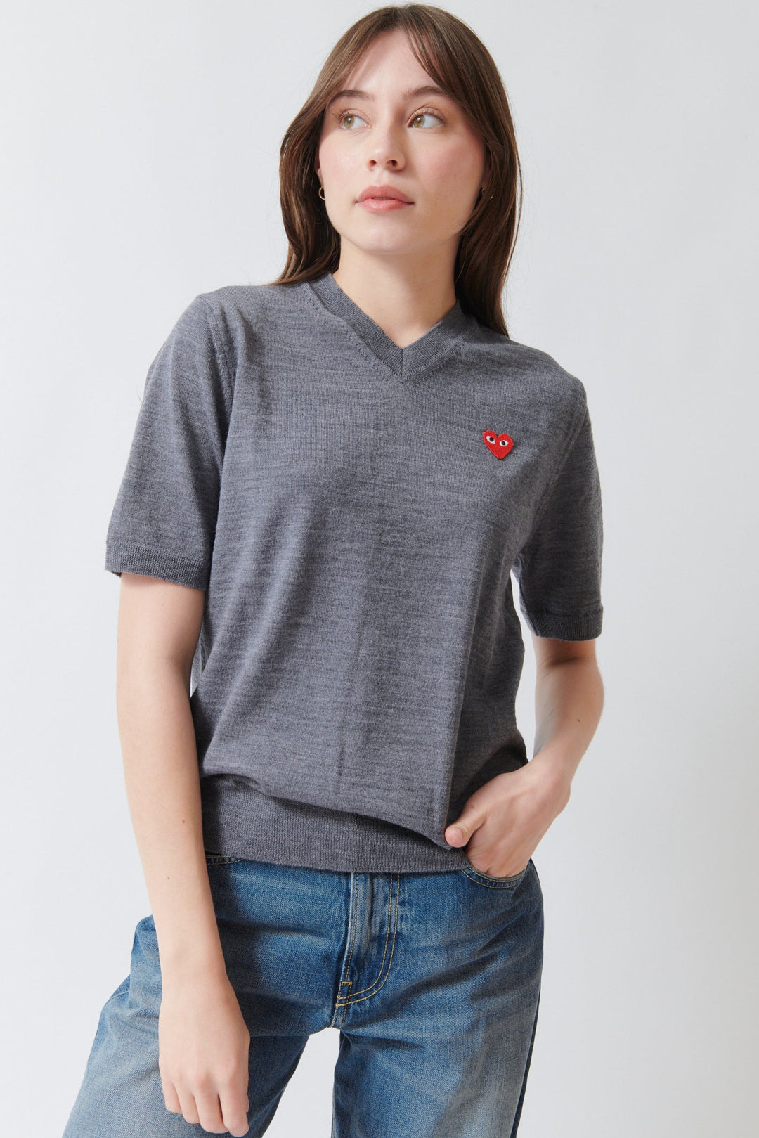 Angela wearing Comme des Garçons PLAY Red Heart Emblem Short Sleeve V Sweater Grey front view
