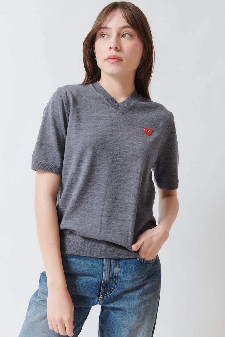 Angela wearing Comme des Garçons PLAY Red Heart Emblem Short Sleeve V Sweater Grey front view