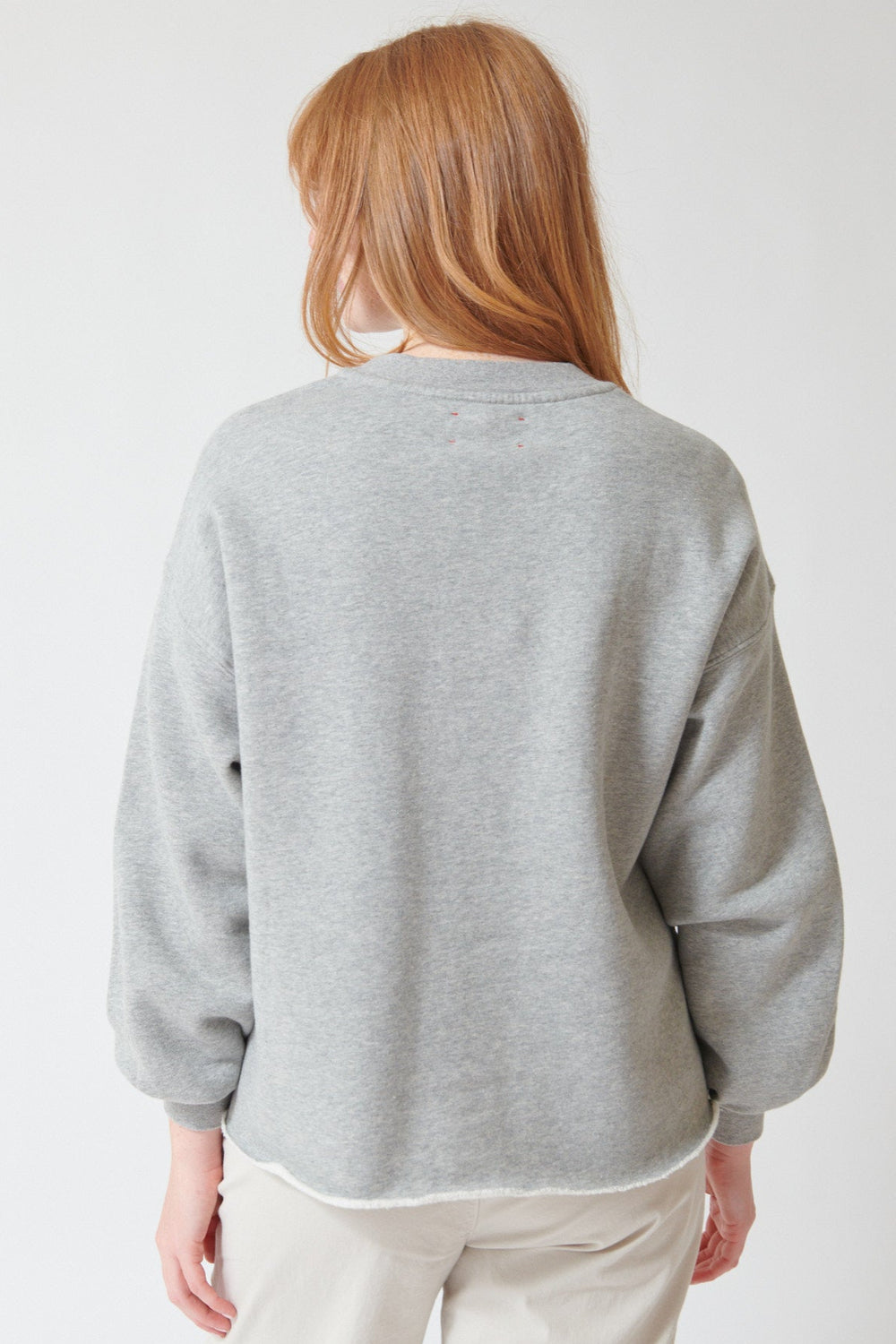 Waverly wearing Xirena Honor Sweatshirt in Heather Grey, rear view.