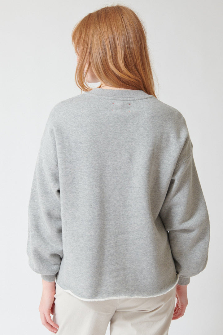Waverly wearing Xirena Honor Sweatshirt in Heather Grey, rear view.