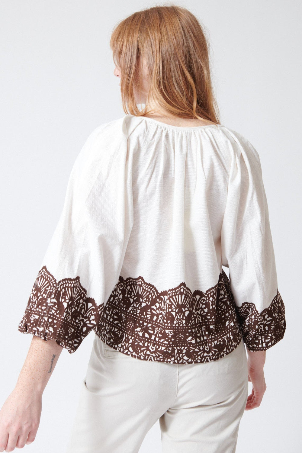Waverly wearing The Great The Chariot Top in Cream with Western Lace, rear view.