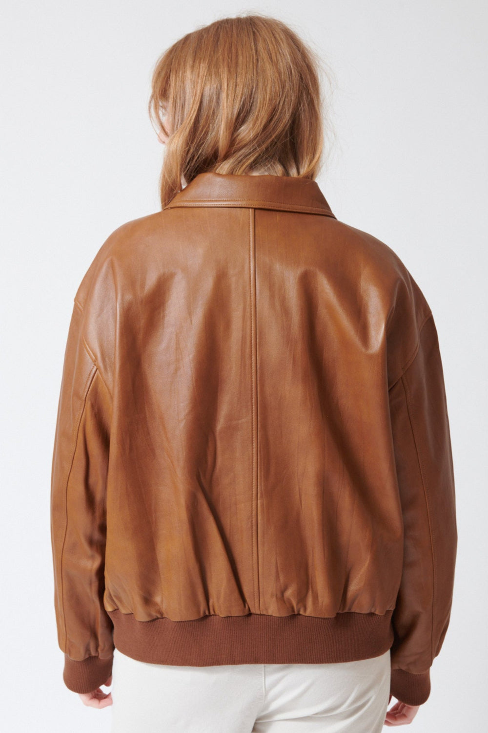 Waverly wearing The Great The Flight Jacket in Saddle Brown, rear view.
