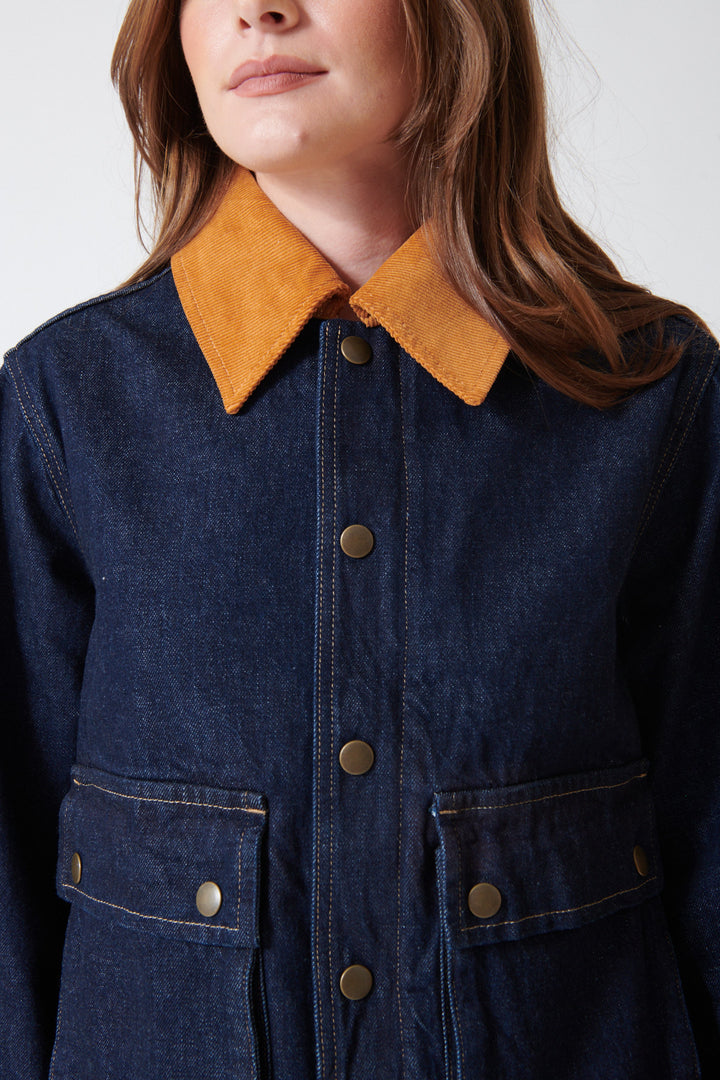 Close up of collar, buttons, and pockets of The Great The Denim Swingy Jacket.