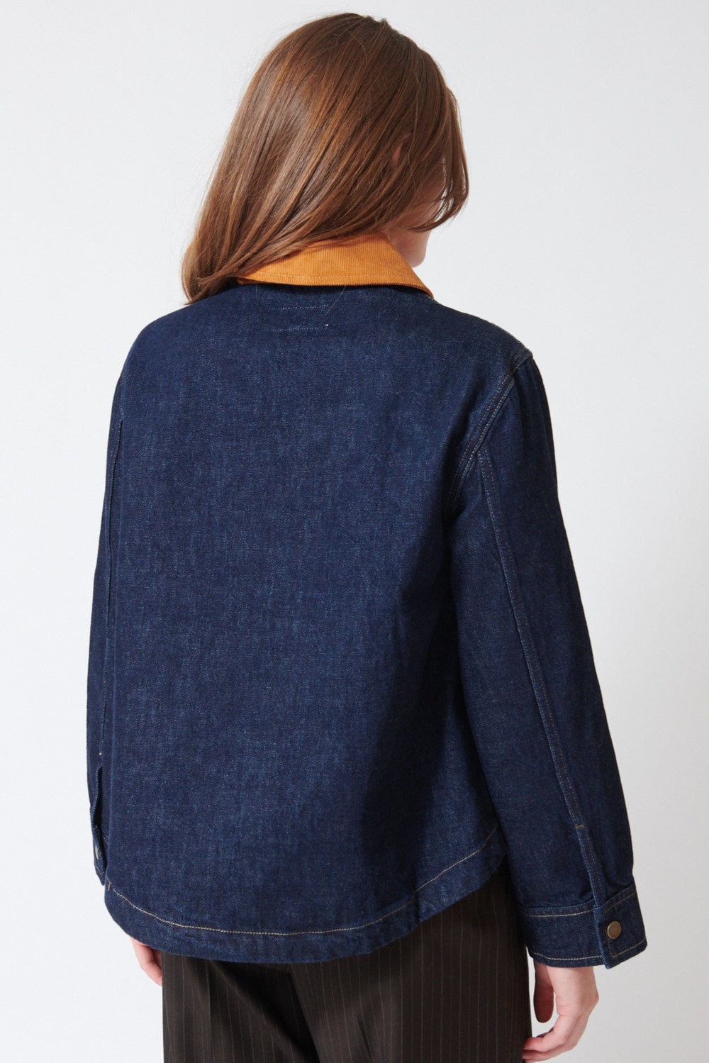 Julia wearing The Great The Denim Swingy Jacket in Midnight Rinse, rear view.