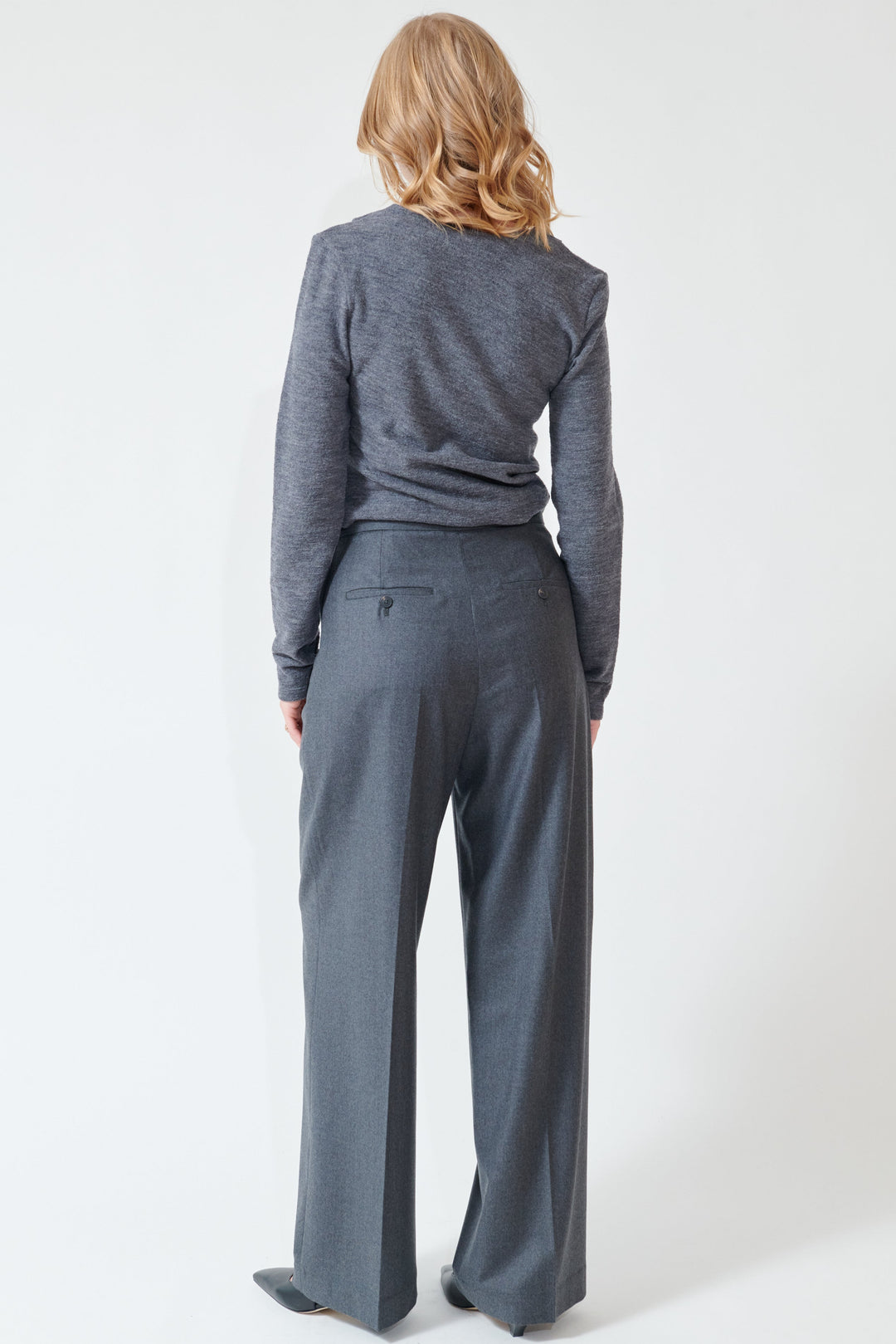 Madi wearing Róhe Relaxed Soft Wool Trousers rear view