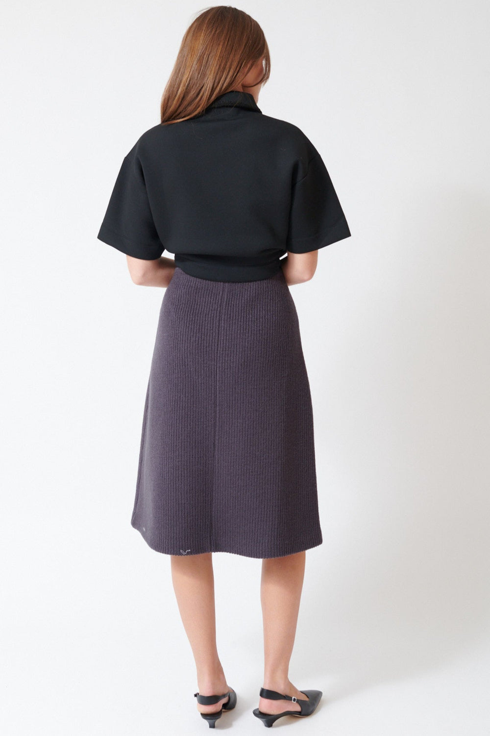 Julia wearing Tela Sadie Skirt in Dark Grey, rear view.