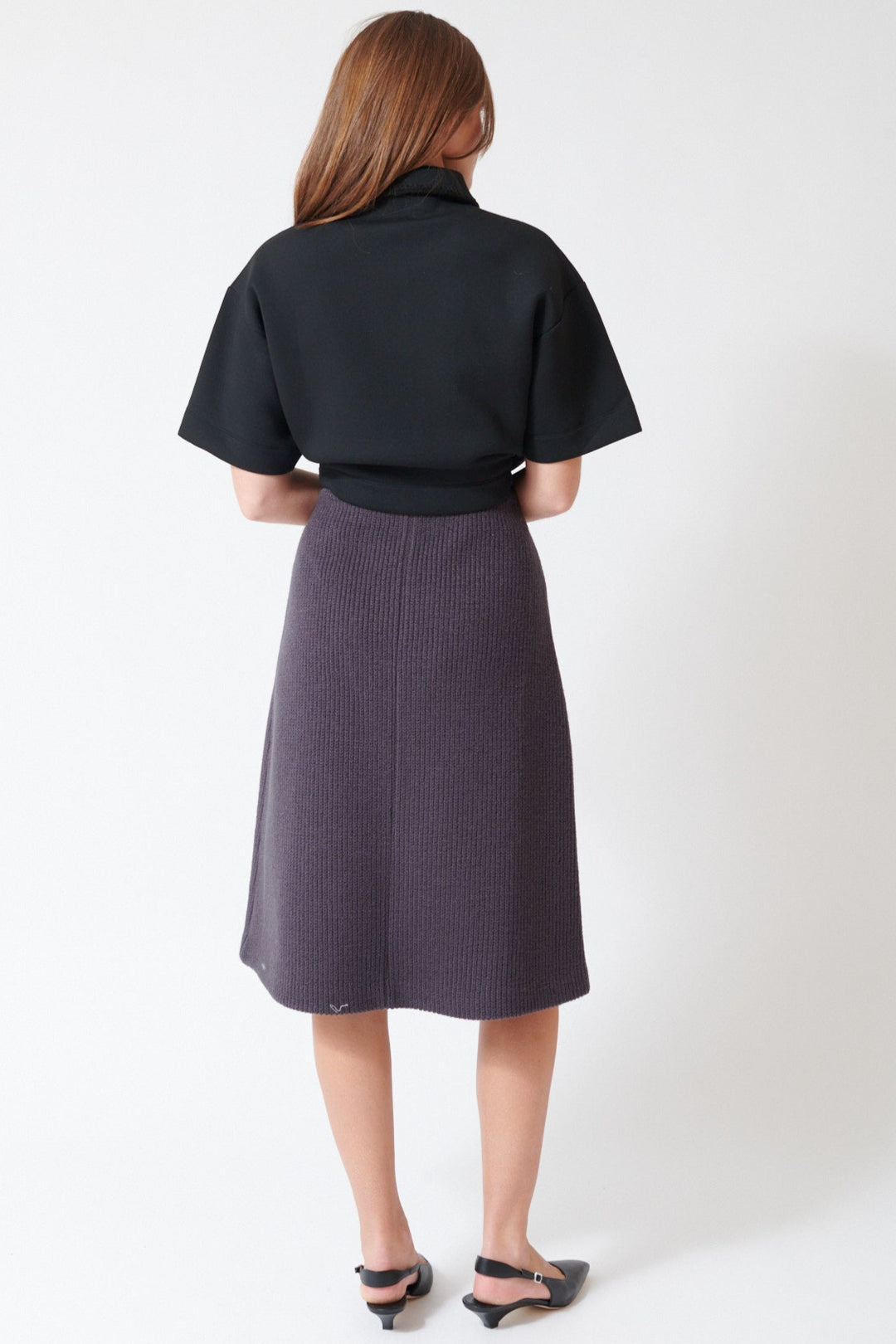 Julia wearing Tela Sadie Skirt in Dark Grey, rear view.