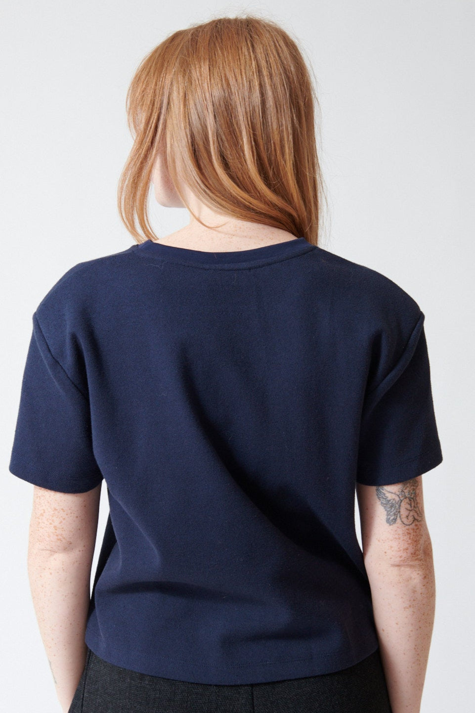 Waverly wearing ELEH Ella Cotton Blend Short Tee With Shoulder Pads in Blue Night, rear view.
