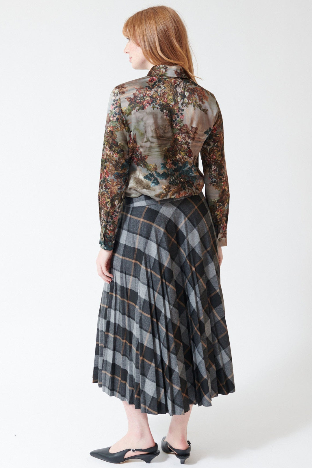 Waverly wearing Peserico Viscose Blend Flannel Check Plisse Skirt in Dark Sapphire Grey, rear view.