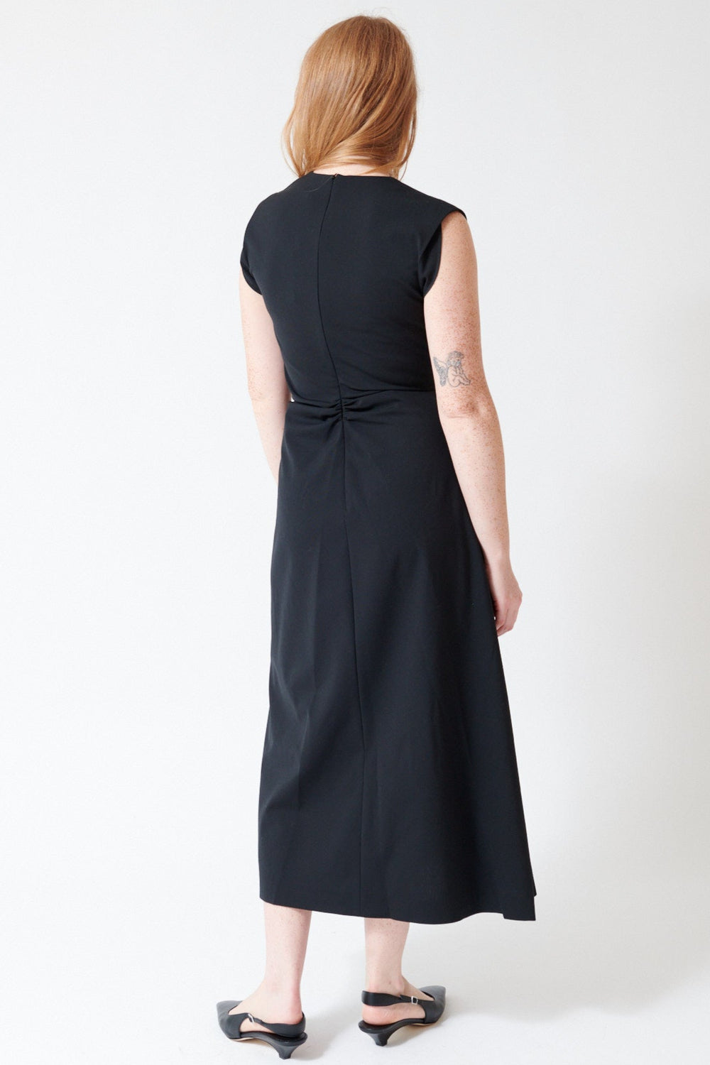 Waverly wearing Mantu Fresco Lana Side Gathered Dress in Black, rear view.
