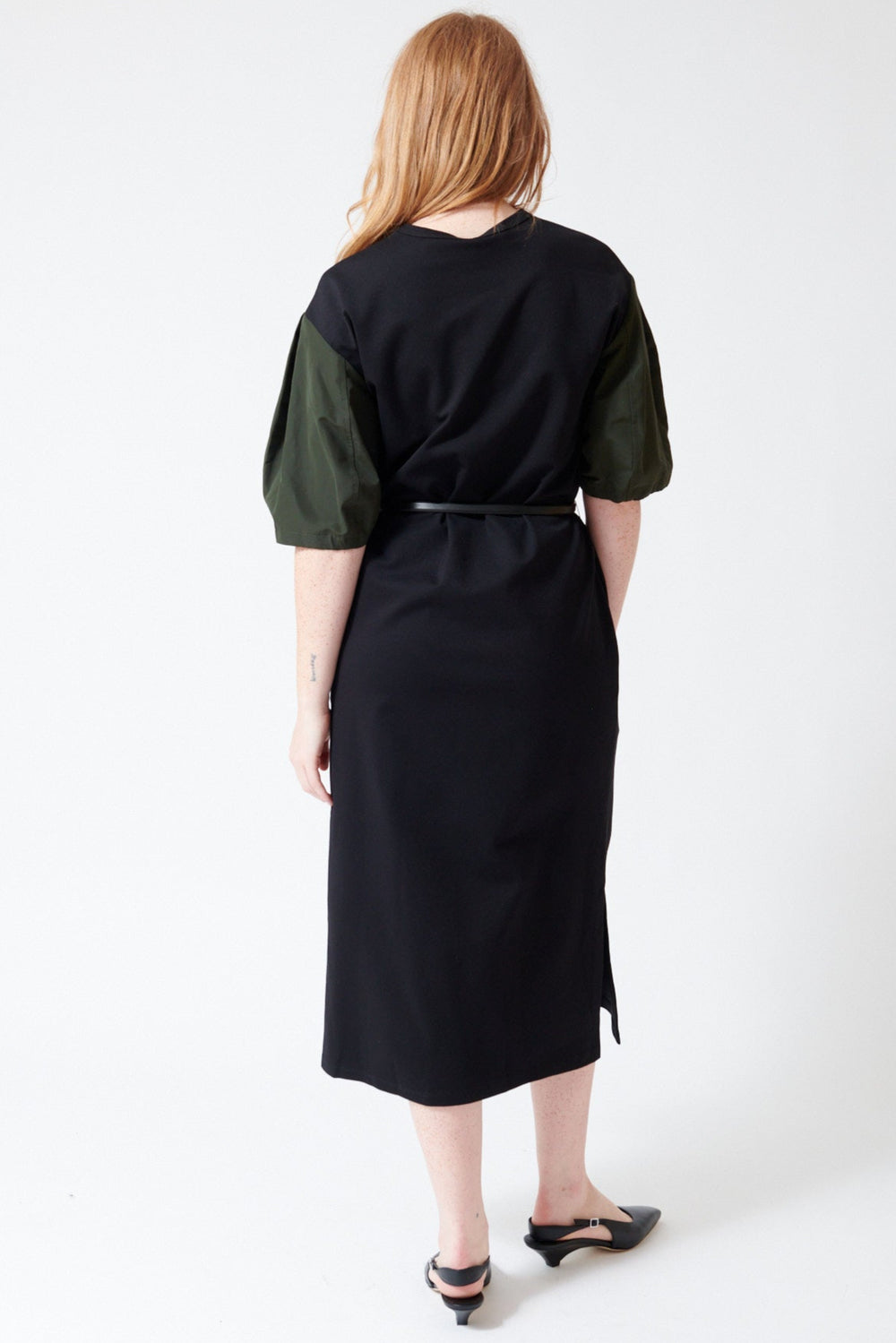 Waverly wearing Mantu Faille Ruched Sleeve Dress in Black Green, rear view.