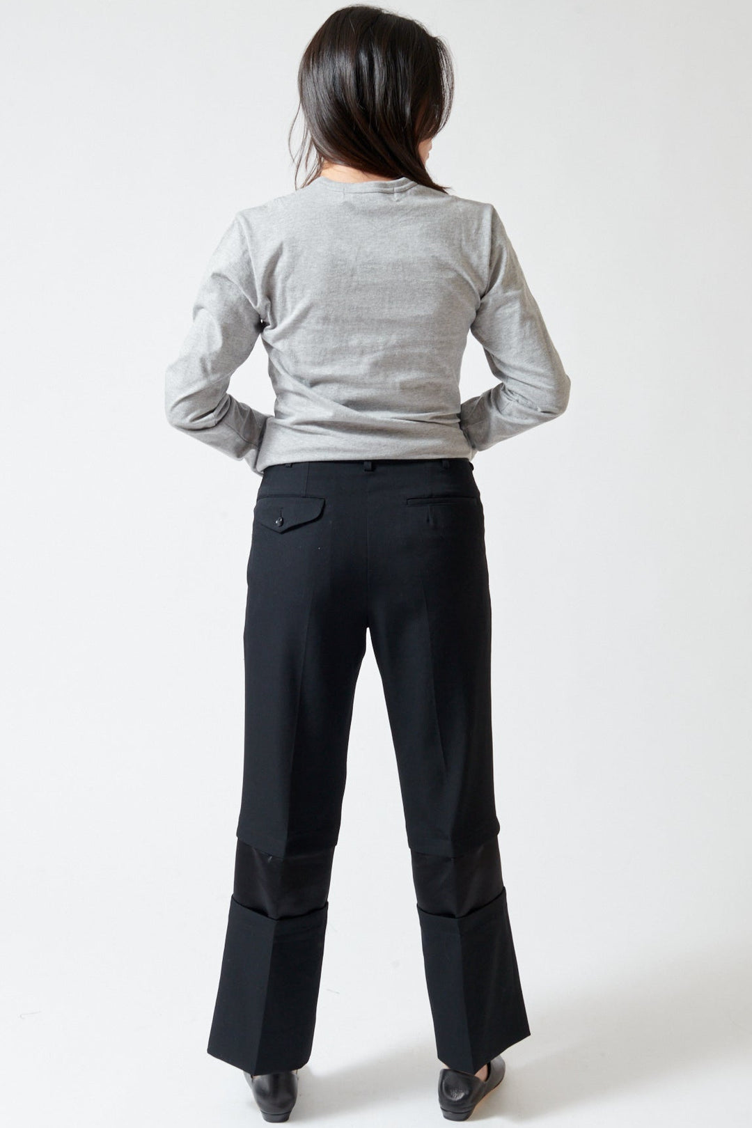 Lilly wearing Comme des Garçons Wool Gabardine x Poly Satin Banded Leg Trouser rear view