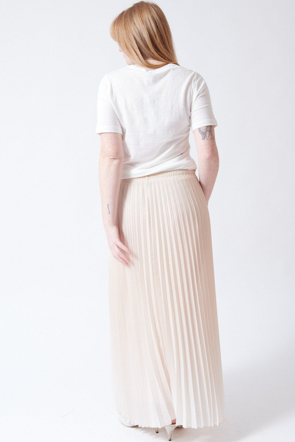 Waverly wearing SCAGLIONE Long Shade Plisse Skirt rear view