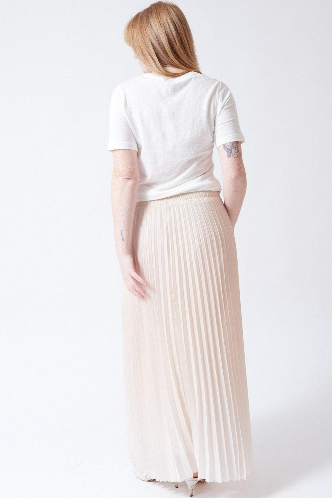 Waverly wearing SCAGLIONE Long Shade Plisse Skirt rear view