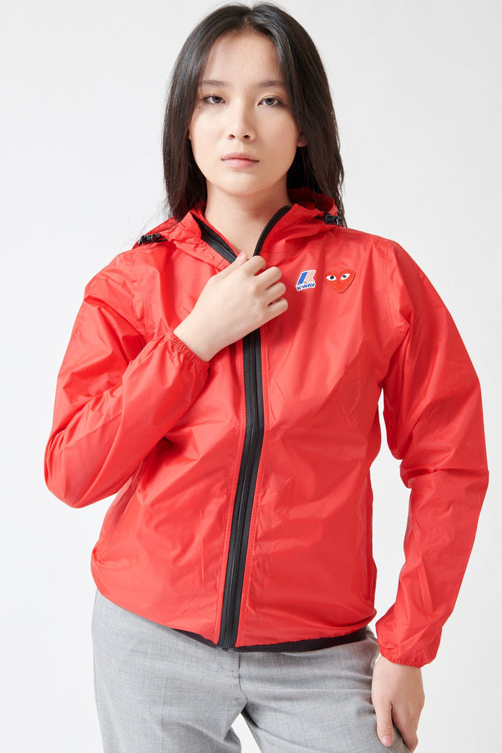 Lilly wearing Comme des Garçons PLAY K-Way Full Zip Red Emblem Unisex Jacket Red front view