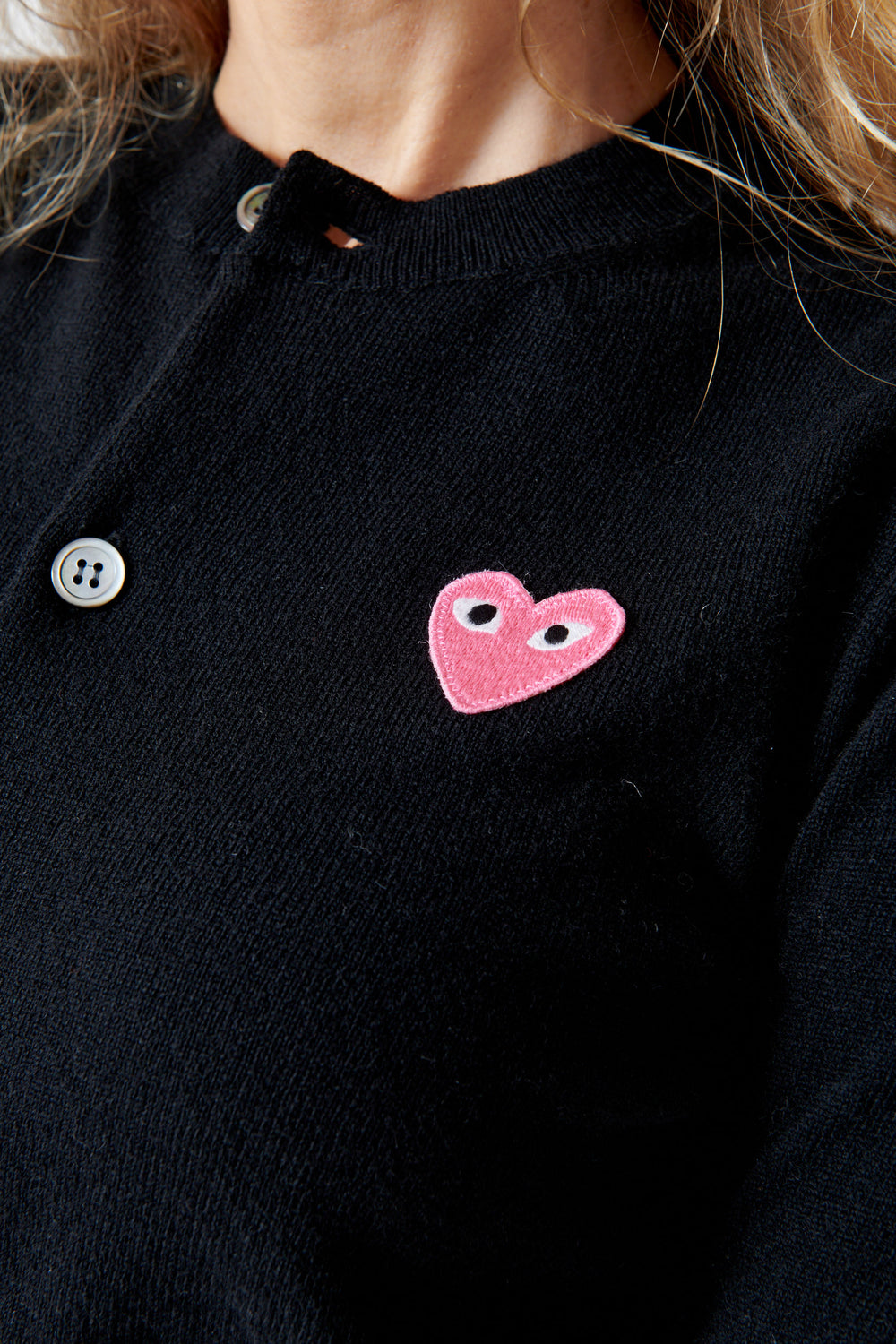 Mari wearing Comme des Garçons PLAY Pink Emblem Round Neck Cardigan Black front detail view