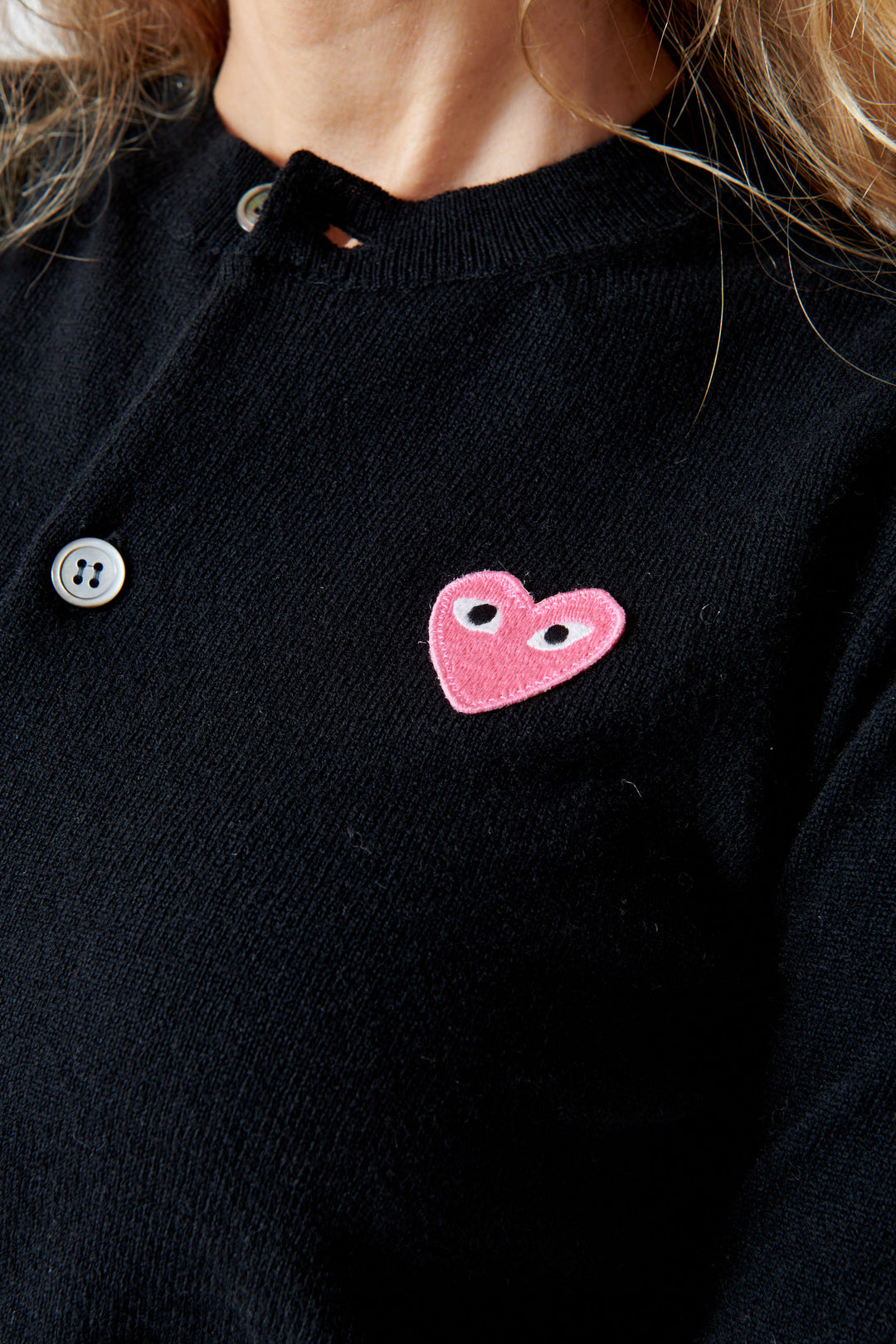 Mari wearing Comme des Garçons PLAY Pink Emblem Round Neck Cardigan Black front detail view