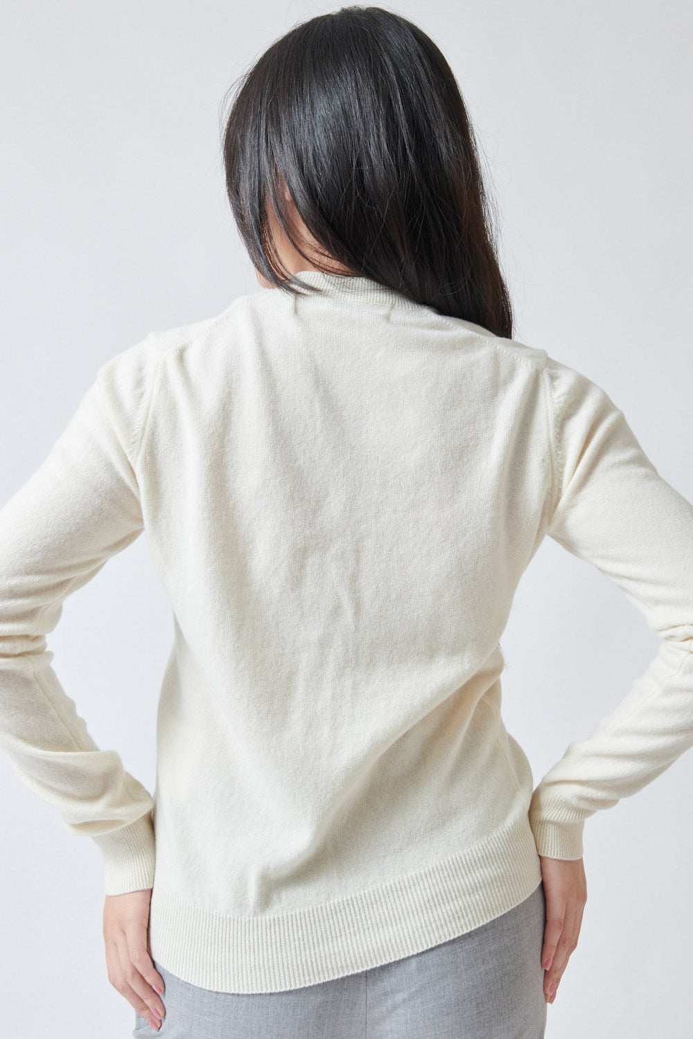 Lilly wearing Comme des Garçons PLAY Pink Emblem Round Neck Cardigan Natural rear view