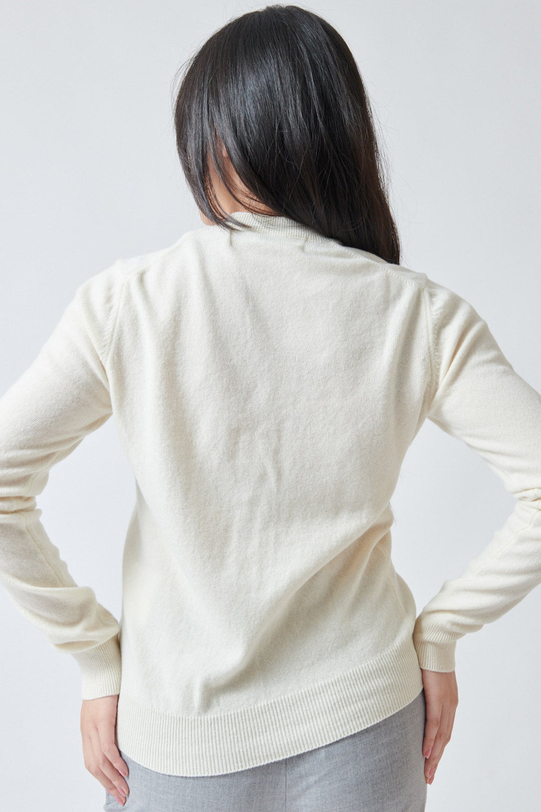 Lilly wearing Comme des Garçons PLAY Pink Emblem Round Neck Cardigan Natural rear view