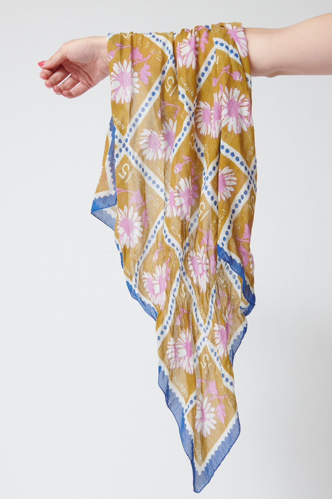 Model holding Épice Carre Bandana Ochre front view