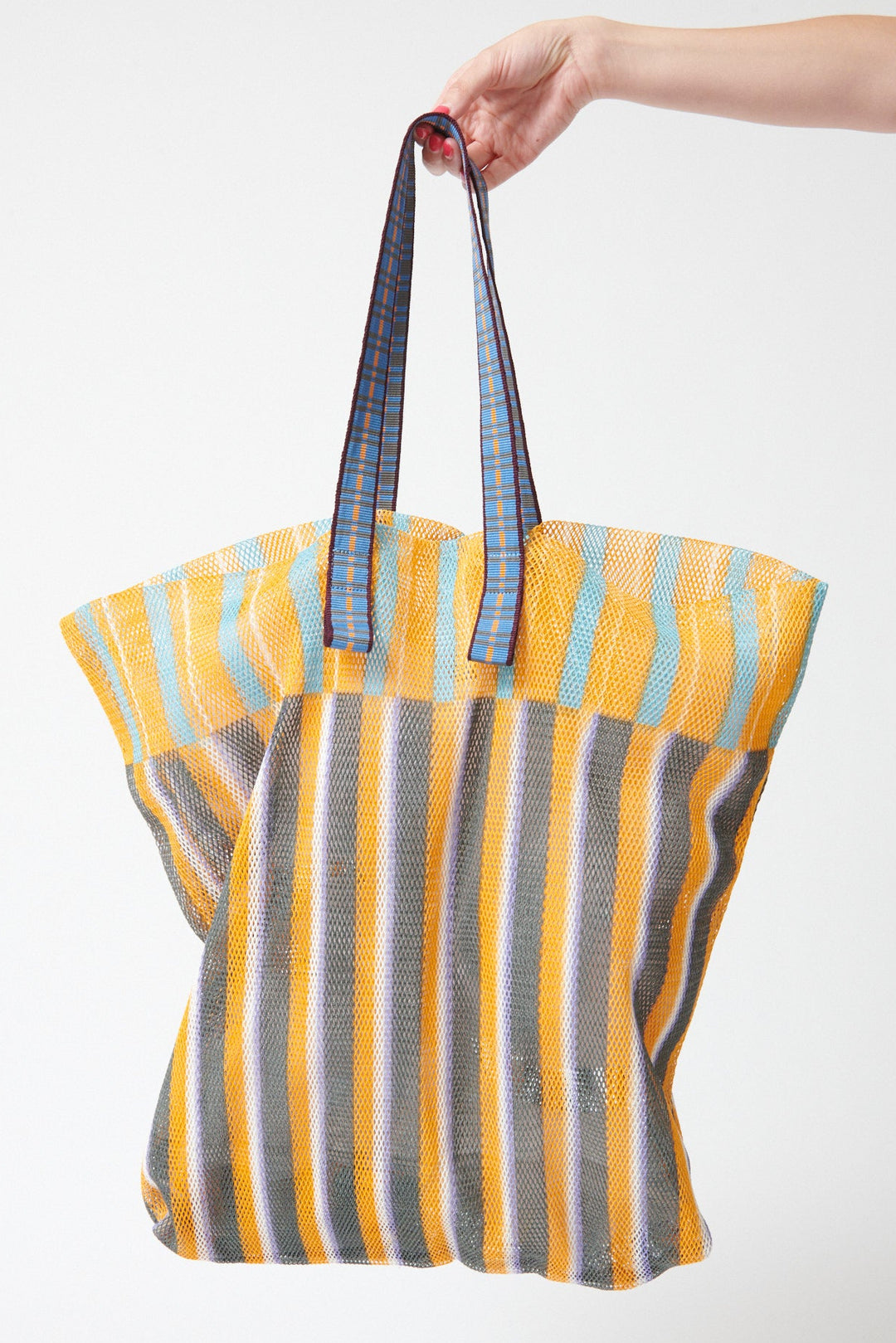 Model holding Épice Extra Large Stripe Mesh Tote Sunflower front view