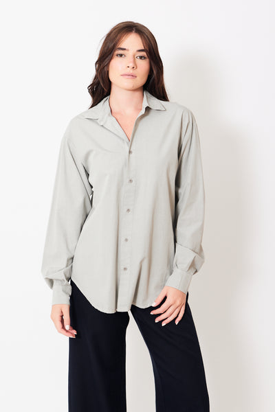 Front view of model wearing grey button up shirt