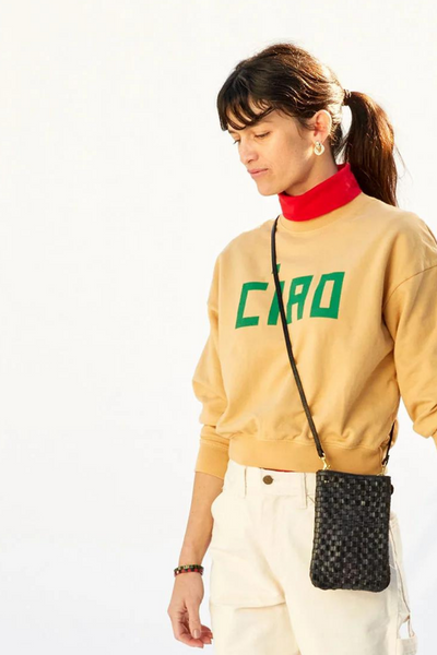 Clare V. Poche bag around a model's shoulder