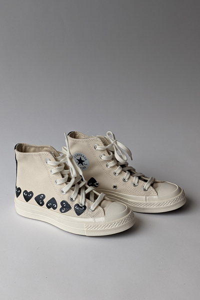 Front, side view of Comme des Garçons PLAY Multi Heart Converse Chuck Taylor High Top shoes
