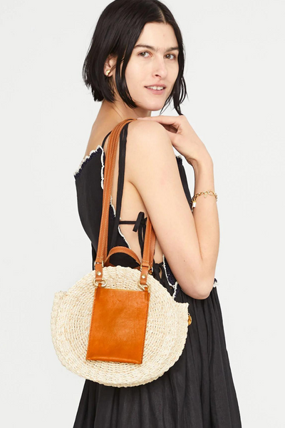 Side/back view of model wearing cream handbag with leather strap  