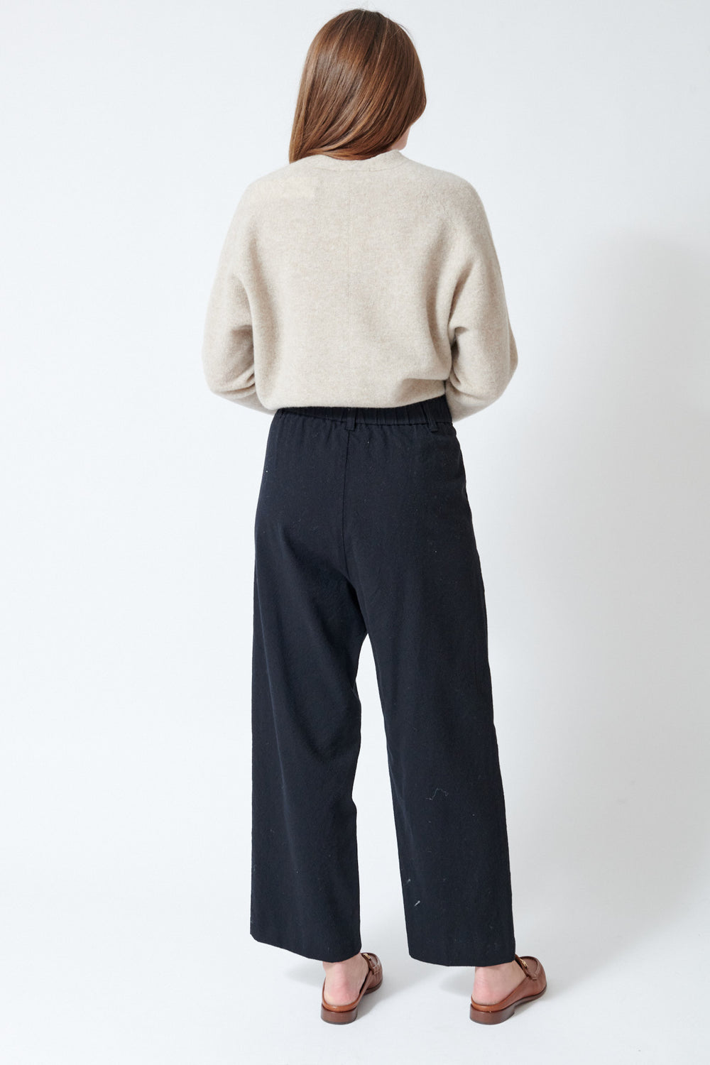 Julia wearing Pas de Calais Mulesing Free Wool Cotton Wide Pants in Black, rear view.