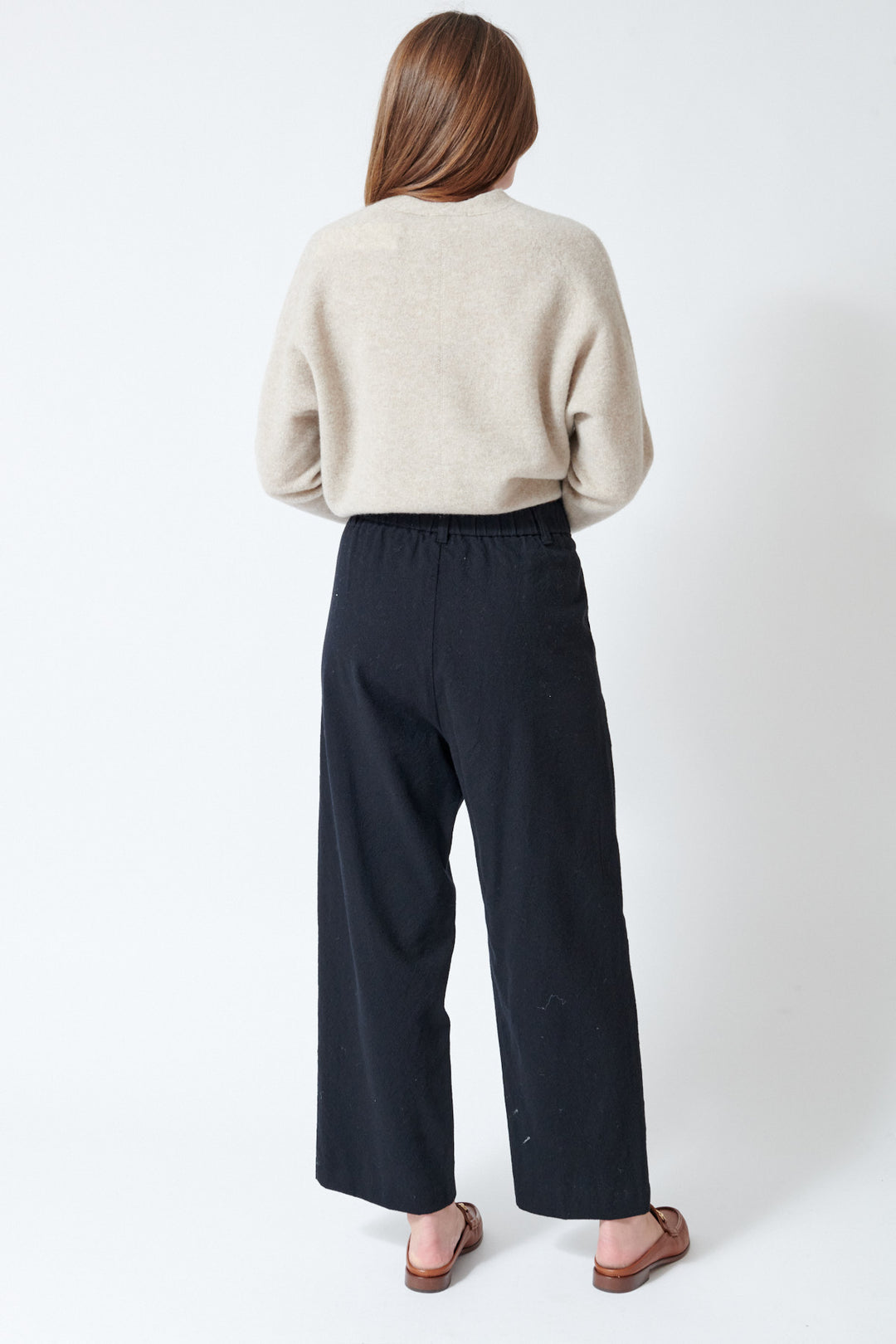 Julia wearing Pas de Calais Mulesing Free Wool Cotton Wide Pants in Black, rear view.