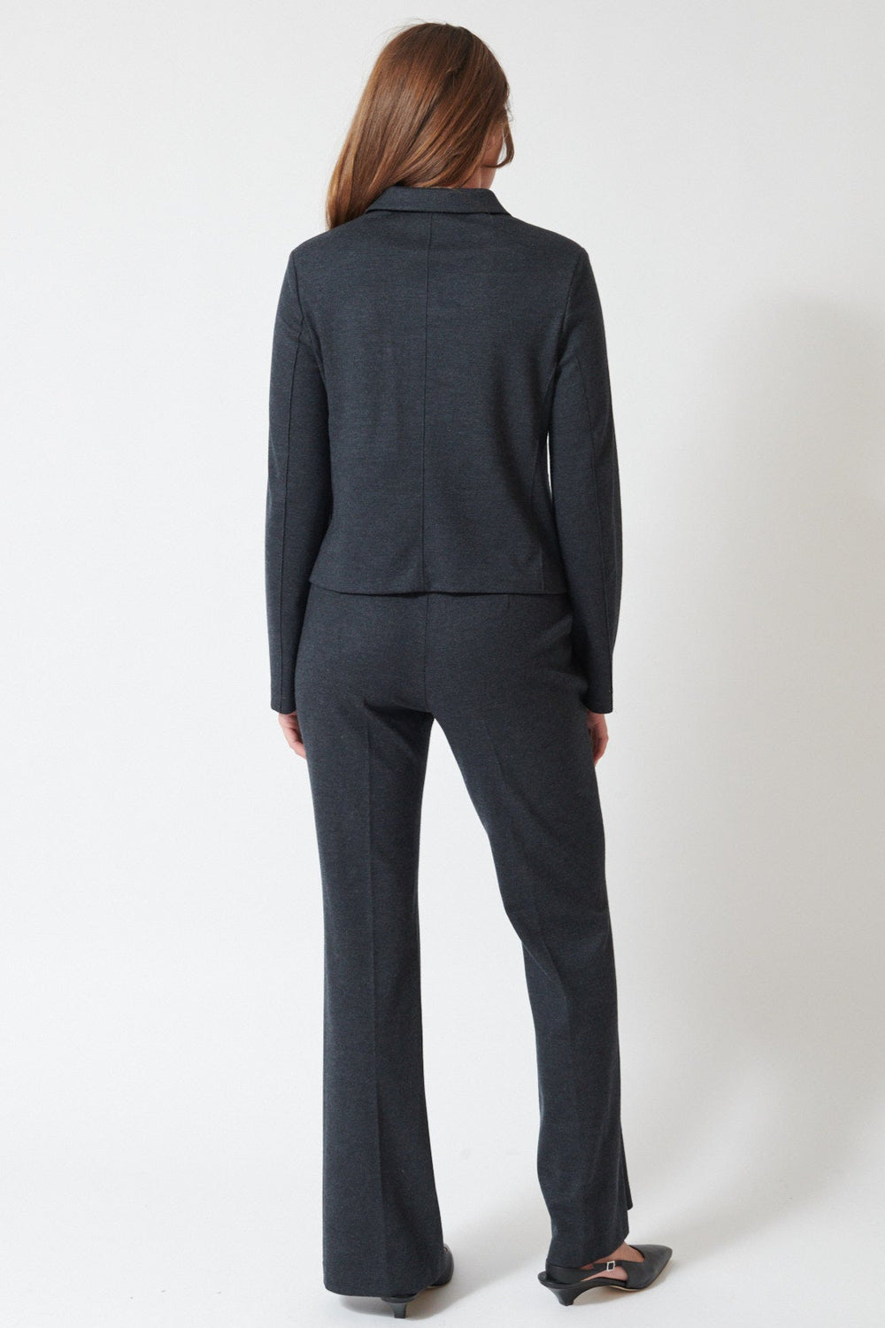Julia wearing Harris Wharf Superfine Merino Flared Fitted Trousers in Anthracite, rear view.